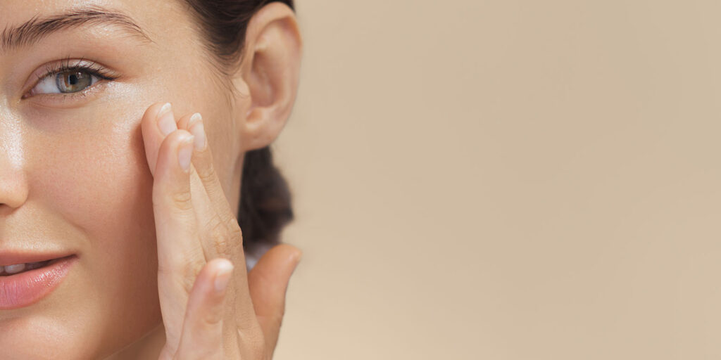 Close-up of a woman touching the skin beneath her eye with her fingers