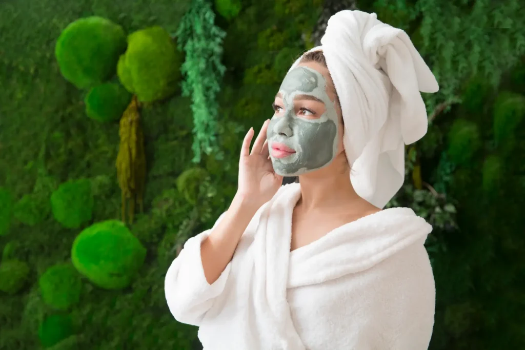Woman in a robe and towel wearing a facial mask in a spa setting